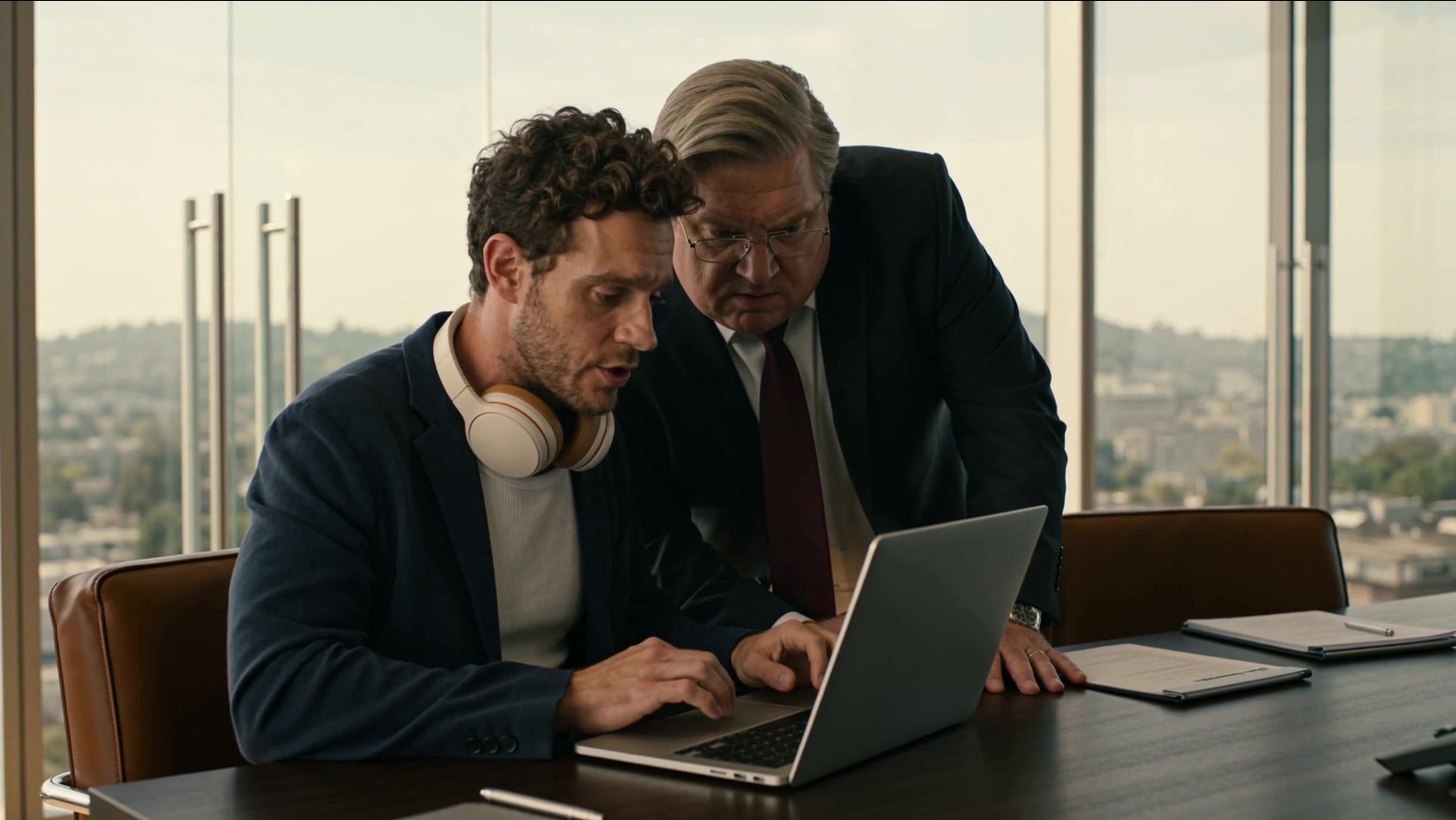The CORA commercial: an analyst and a managing director over one laptop in the boardroom